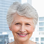 Senior woman smiling with a cityscape background