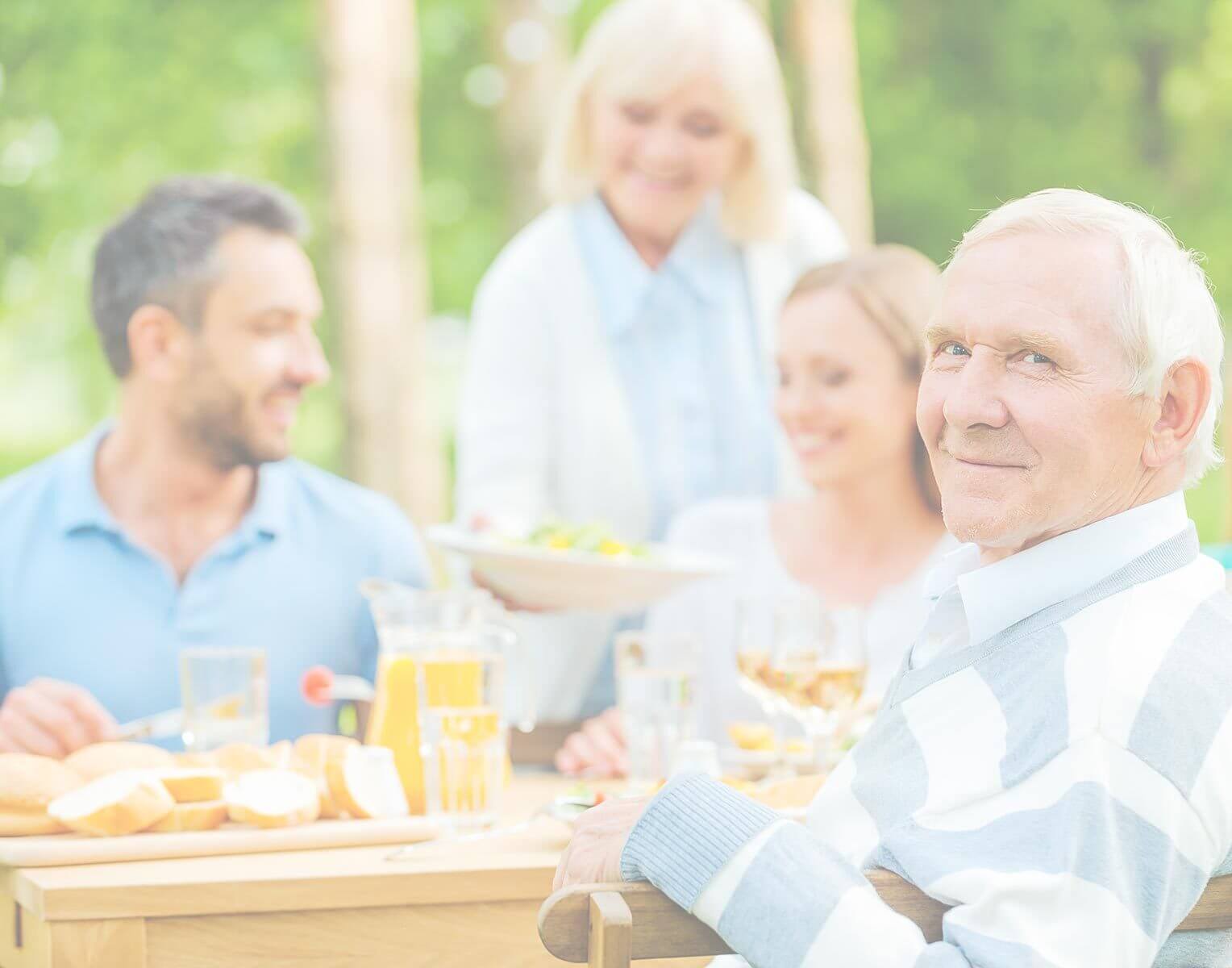 Senior man and woman enjoying outdoor lunch with family